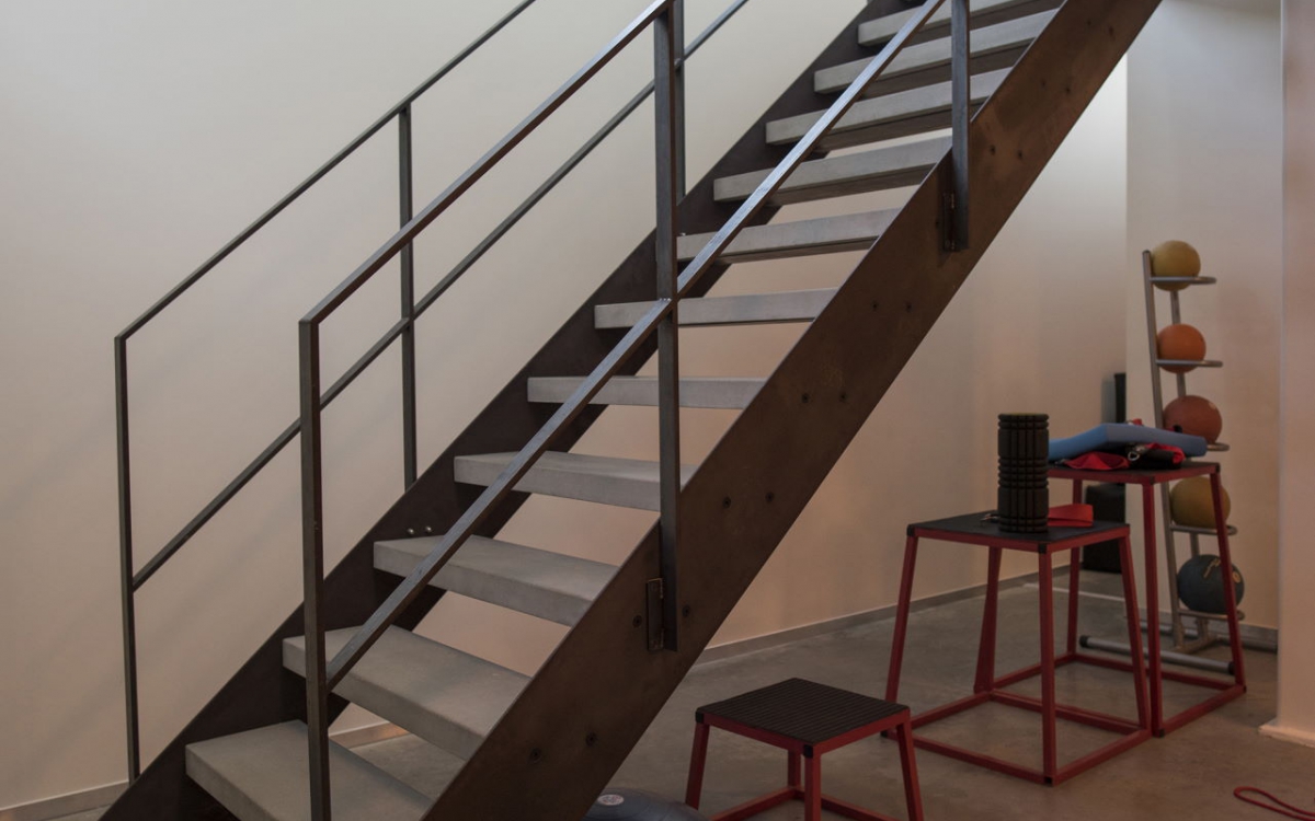 escalier avec 2 limons en acier, marches en béton, rampe en acier avec poteaux horizontales